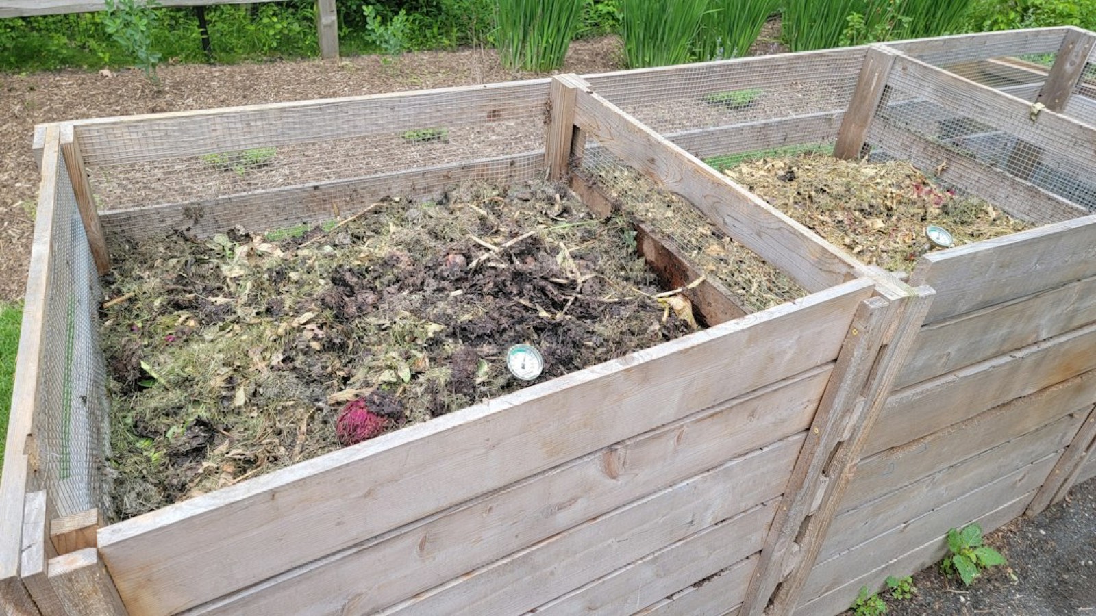 Carré potager en bois posé sur un sol préparé, avec la terre visible à l'intérieur de la structure